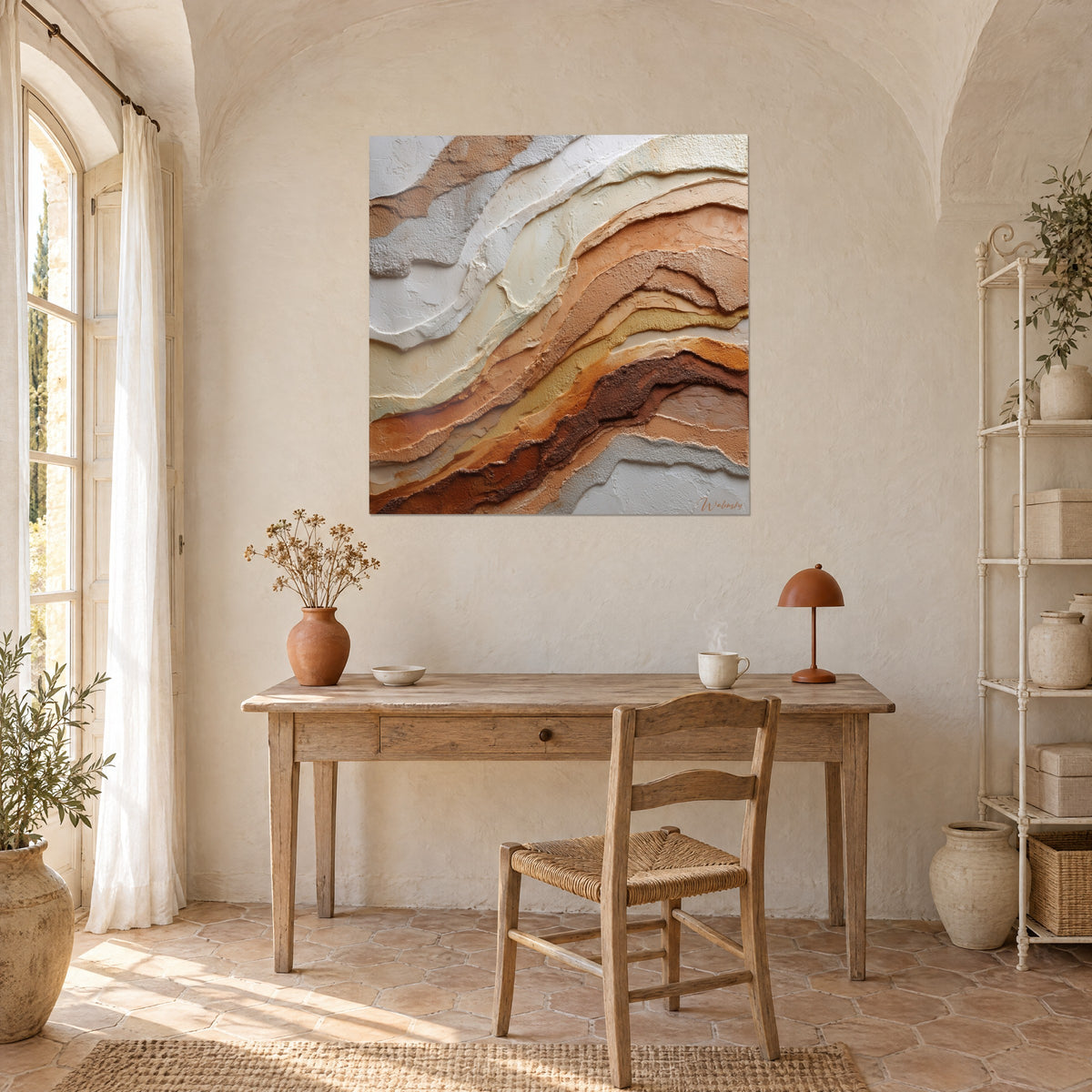 Quadro con materia di gesso in colature marroni e avorio, parete a calce sopra una scrivania in legno chiaro con lampada terracotta