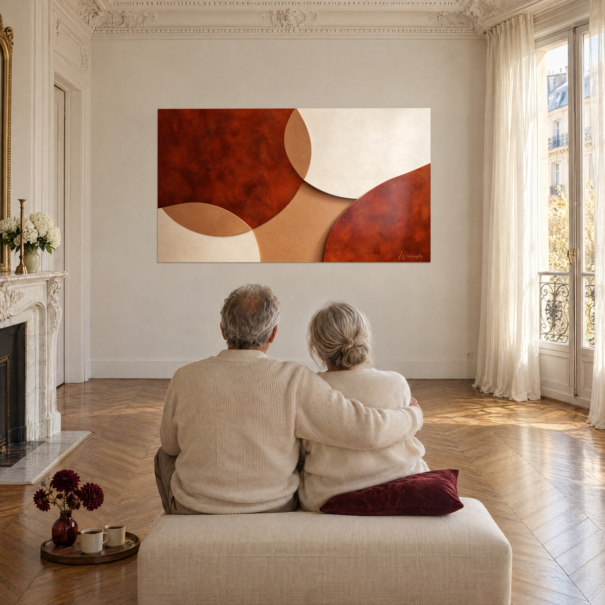 Tableau aplats courbes cuivrés et blanc cassé, texture veloutée, face à un couple assis sur une banquette en lin crème
