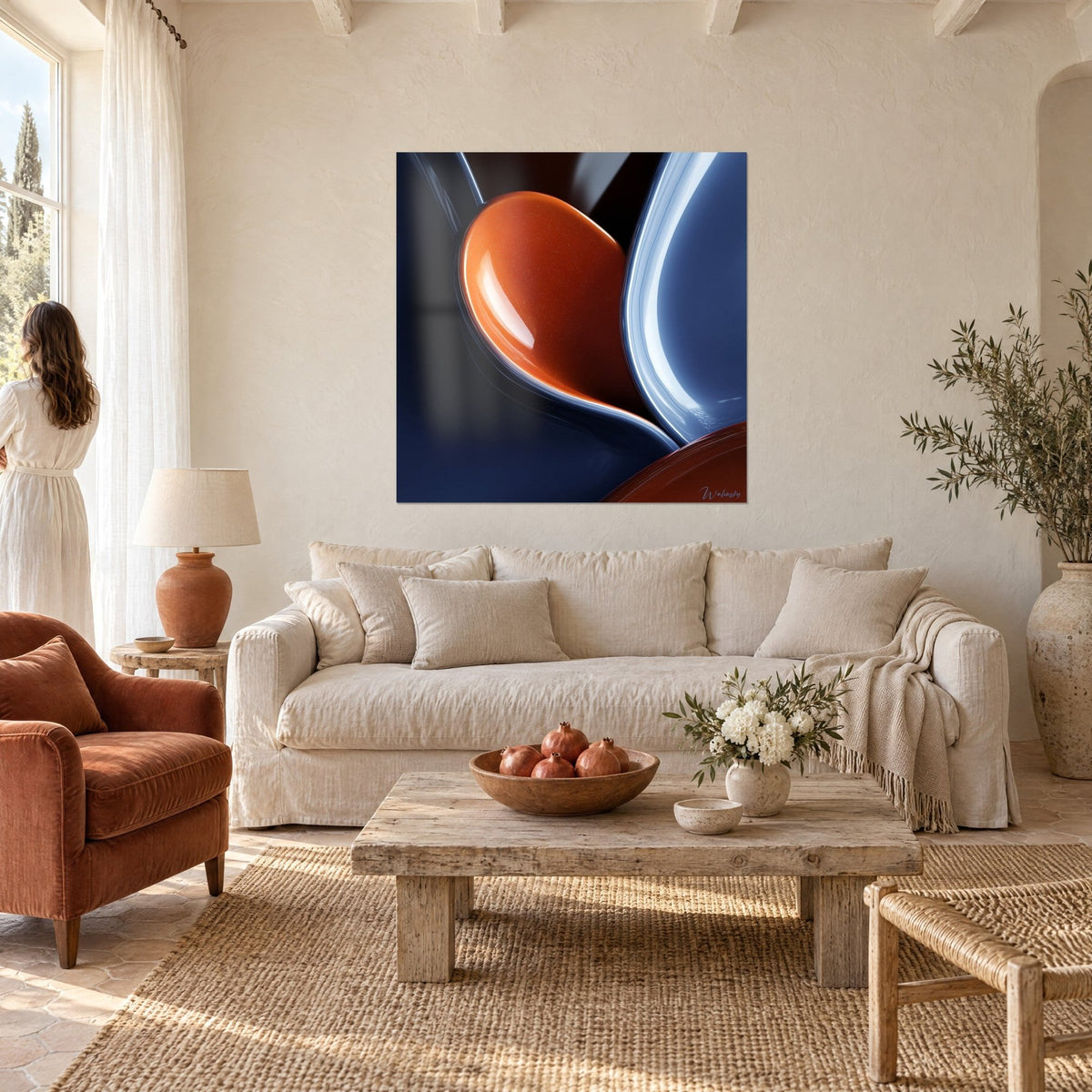 Quadro goccia arancione laccata e scolpita, blu navy e riflessi metallici, donna di spalle, sopra un divano in un soggiorno luminoso