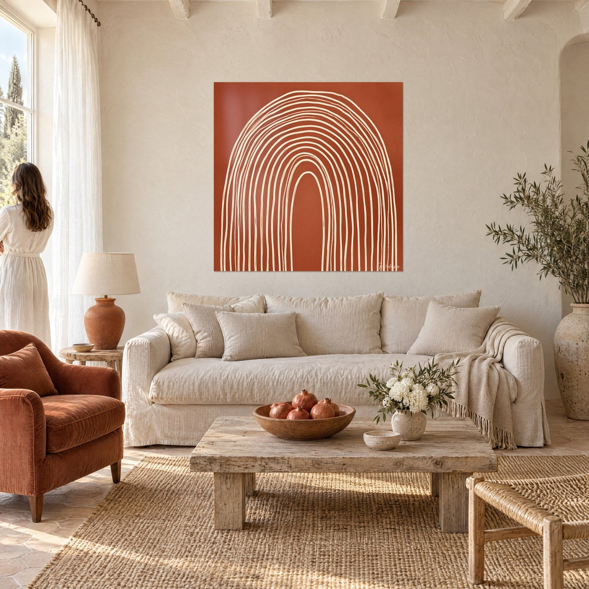 Wall art with a concentric cream arch on a brick background, woman seen from behind in a white dress, above a sofa in a bright living room