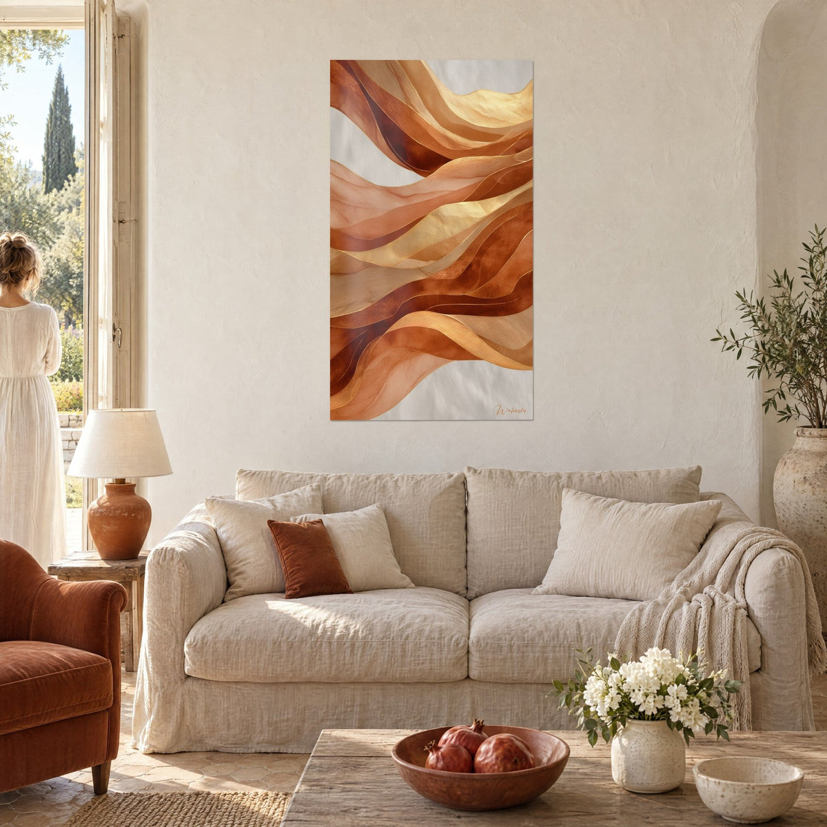 Quadro di nastri di seta ondulati terracotta e oro, sopra un divano di lino beige in un soggiorno luminoso