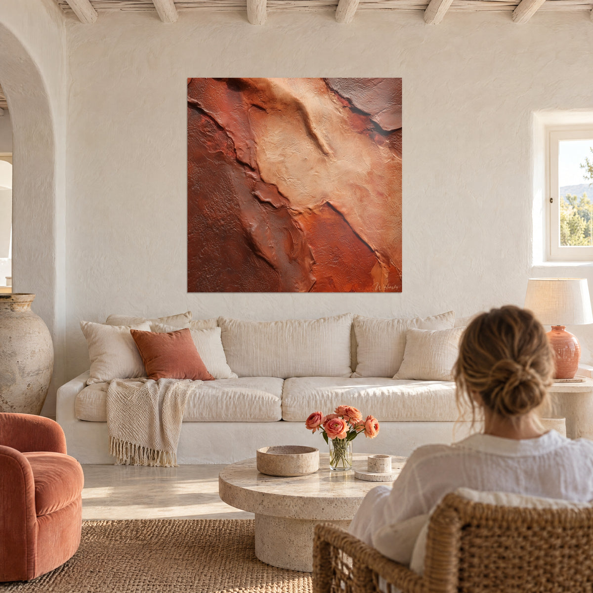 Tableau faille rocheuse ocre et brun rouille, strates craquelées en relief, au-dessus d'un canapé dans un salon lumineux
