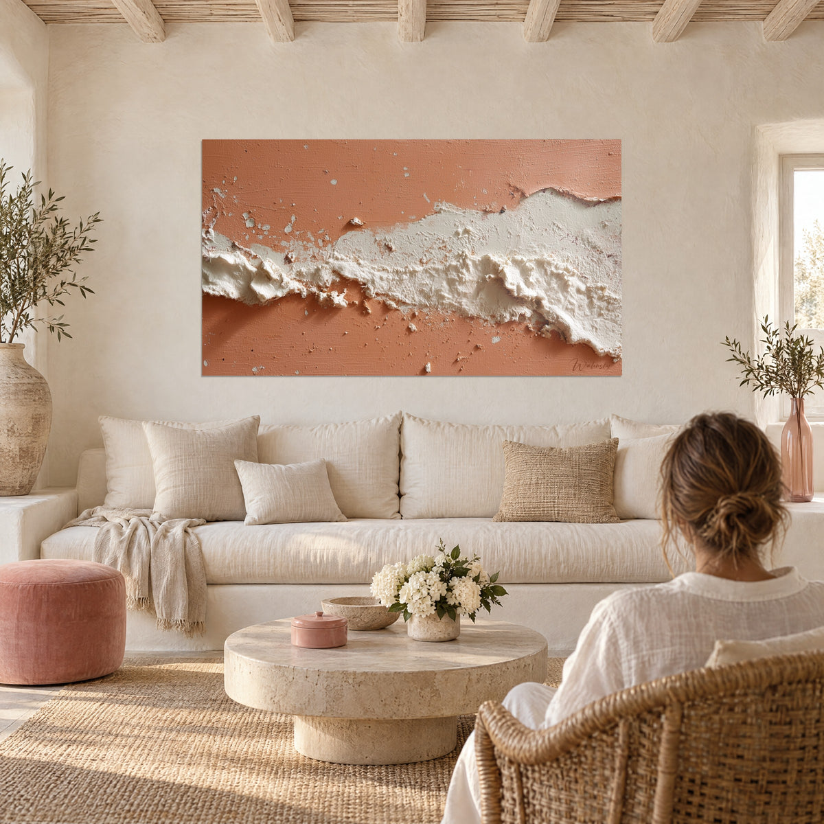 Tableau coulée de plâtre ivoire sur fond corail, relief écaillé, accroché au-dessus d'un canapé dans un salon lumineux