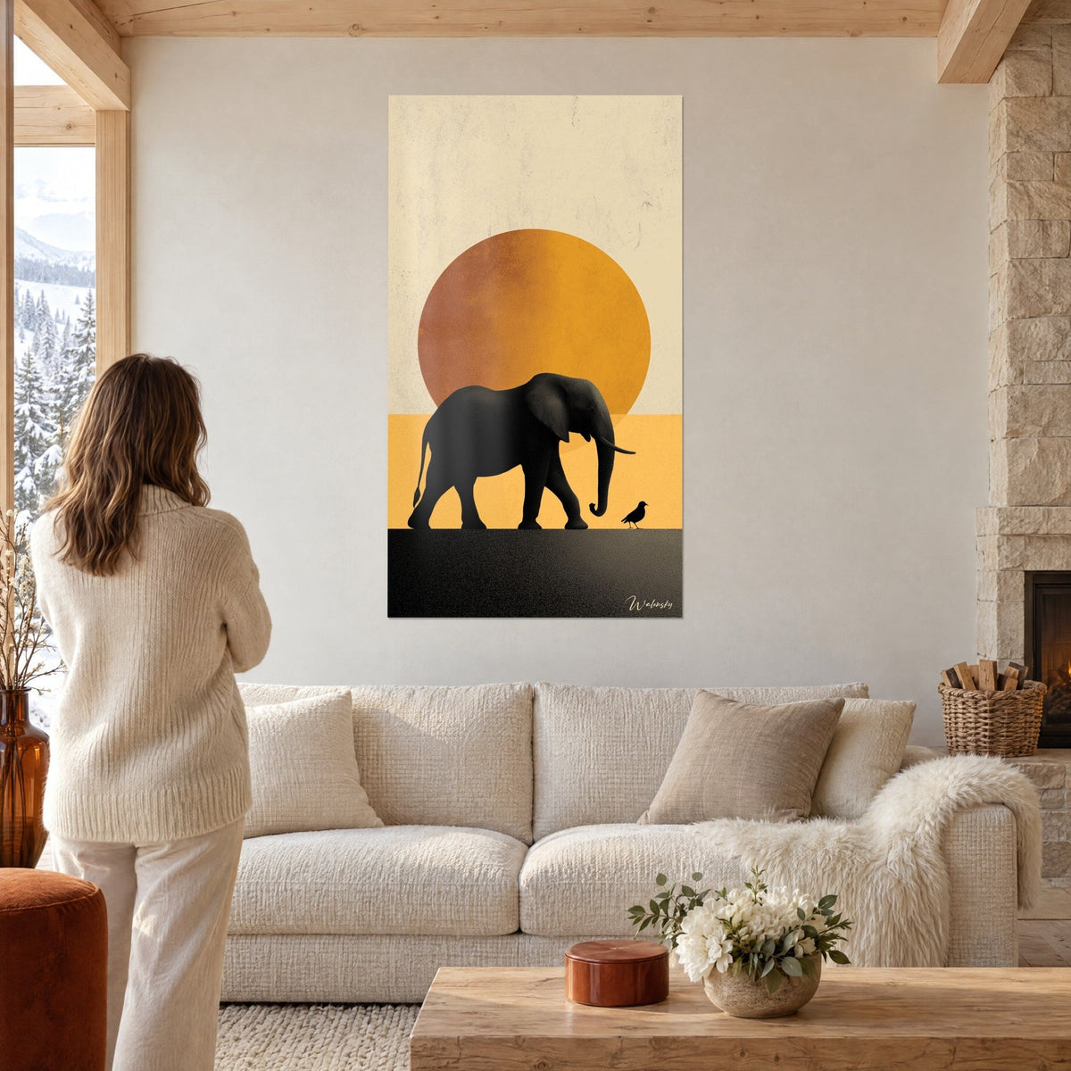 Wall art black elephant walking in front of an ochre disc on cream and honey-yellow background, above a sofa in a bright living room