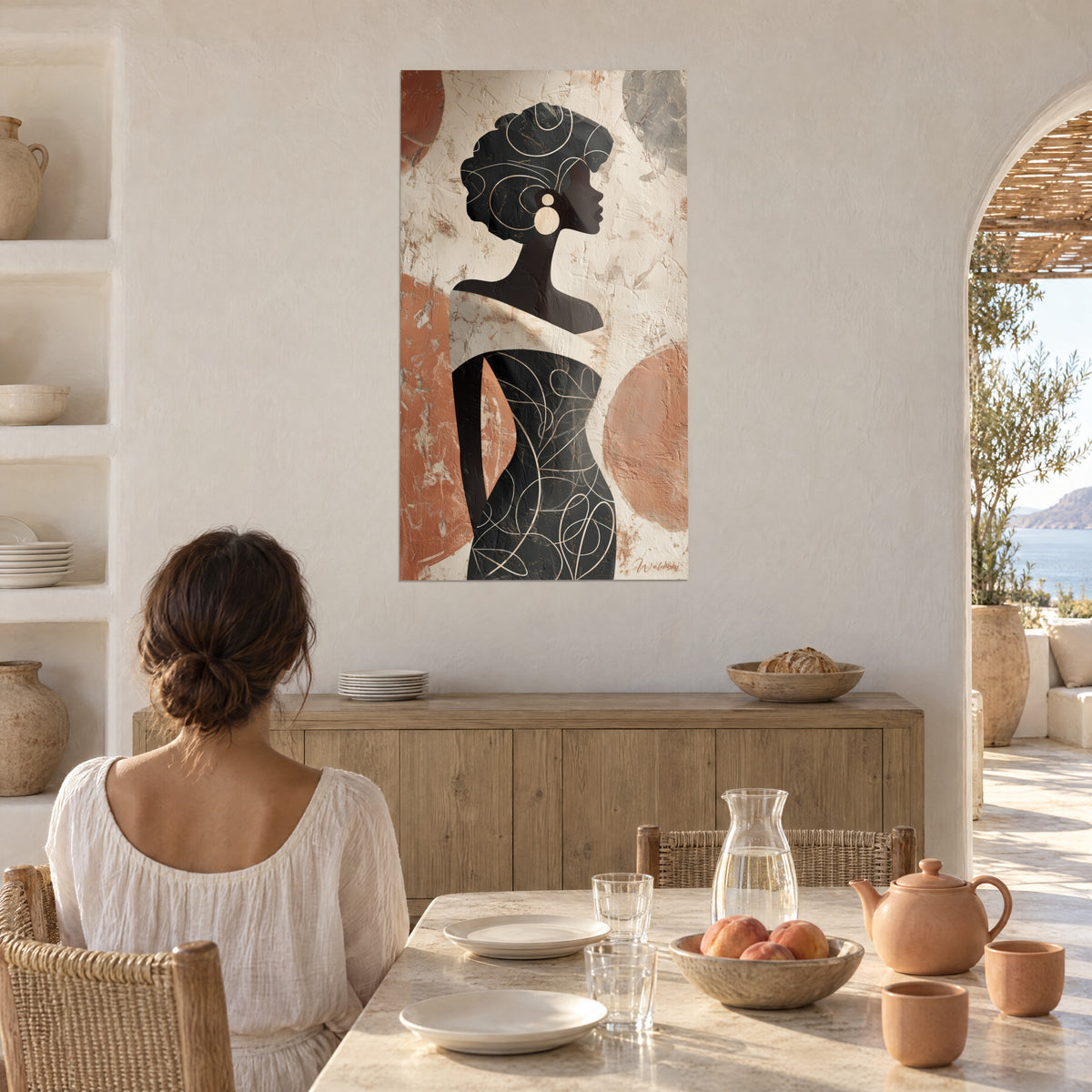 Tableau femme au chignon sculptural noir, disques de terre cuite et gris pâle, face à une table de salle à manger près d'une arche