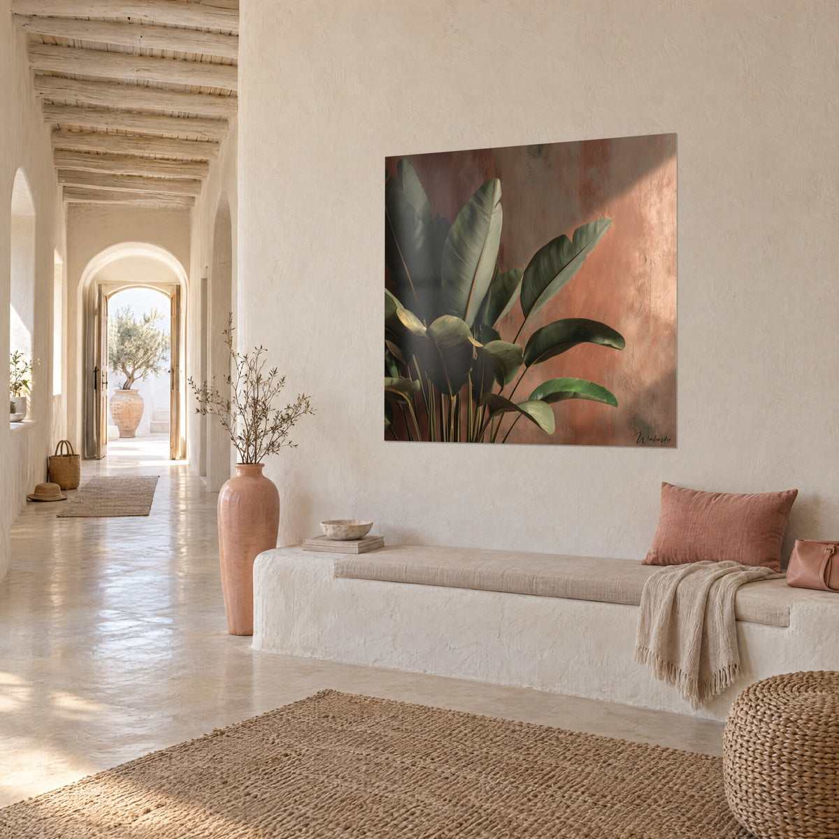 Tableau feuillage tropical vert sombre sur enduit terracotta, vu de biais au-dessus d'une banquette blanche dans une maison méditerranéenne