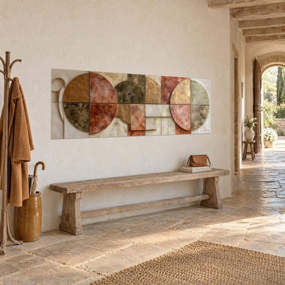 Quadro a mosaico di cerchi terracotta e oro patinato, in rilievo su fondo crema, in un corridoio in pietra