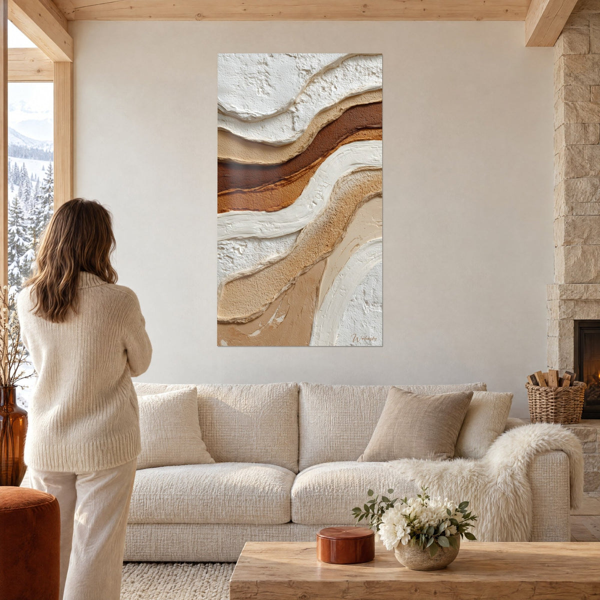 Wall art with sculpted stripes in cream white and cocoa brown in relief, woman seen from behind, above a sofa in a bright living room