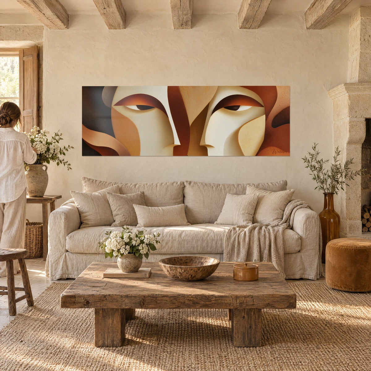 Wall art abstract face with copper-toned eyelids, ivory and terracotta brown planes, above a sofa in a bright living room