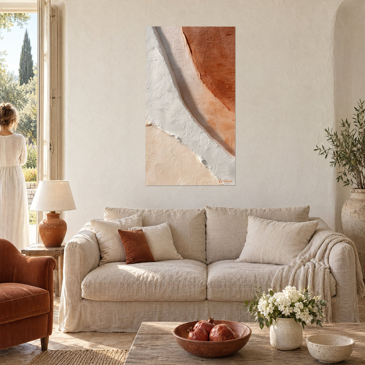 Wall art with a diagonal white fault line between rust and sand, chalky raised texture, above a sofa in a bright living room