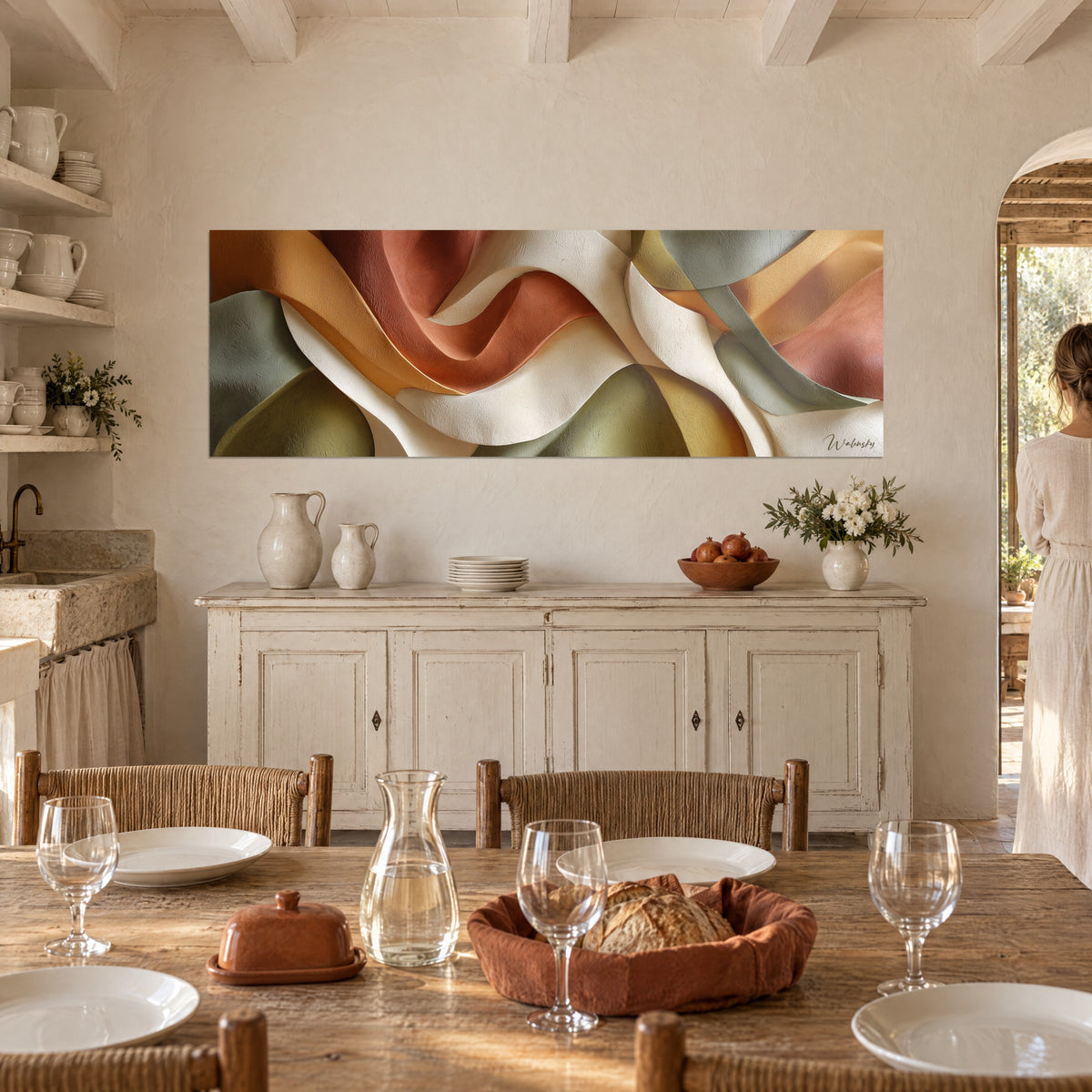 Tableau drapé de pétales ocre, vert olive et crème, vu depuis une table dressée au mas, avec une femme de dos près de la fenêtre