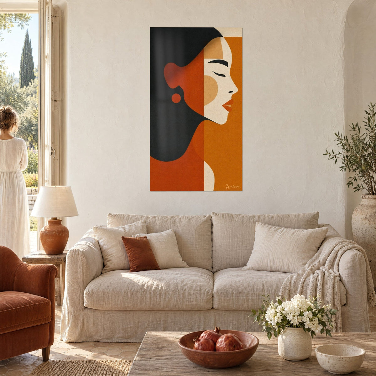 Quadro profilo di donna con gli occhi chiusi, capelli antracite e campiture terracotta, sopra un divano in un soggiorno luminoso