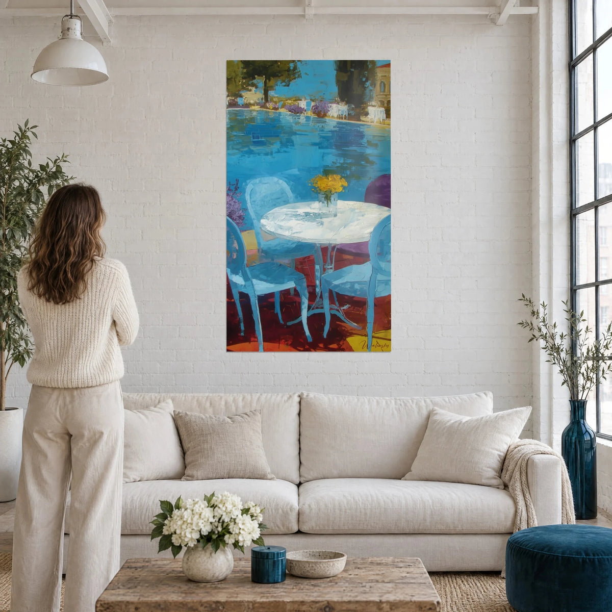 Tableau terrasse au bord d'une piscine bleue, table ronde blanche et bouquet jaune, femme de dos au-dessus d'un canapé dans un salon lumineux