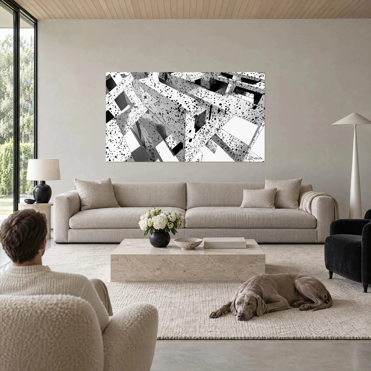 Tableau labyrinthe de dalles éclaboussées d'encre noire sur fond blanc, ombres grises, au-dessus d'un canapé dans un salon lumineux
