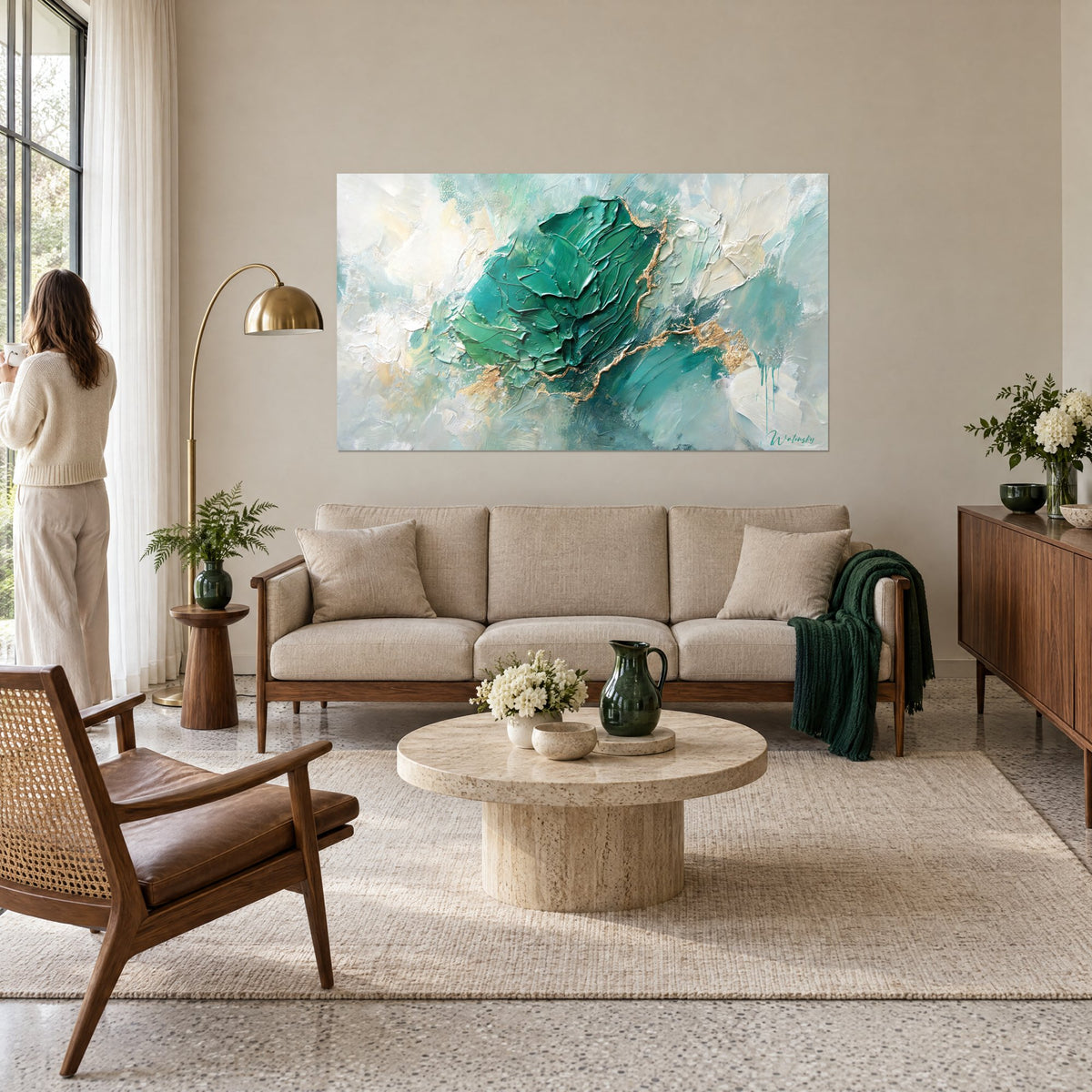 Tableau masse émeraude épaisse veinée d'or sur fond blanc crème, couple de dos, au-dessus d'un canapé dans un salon lumineux