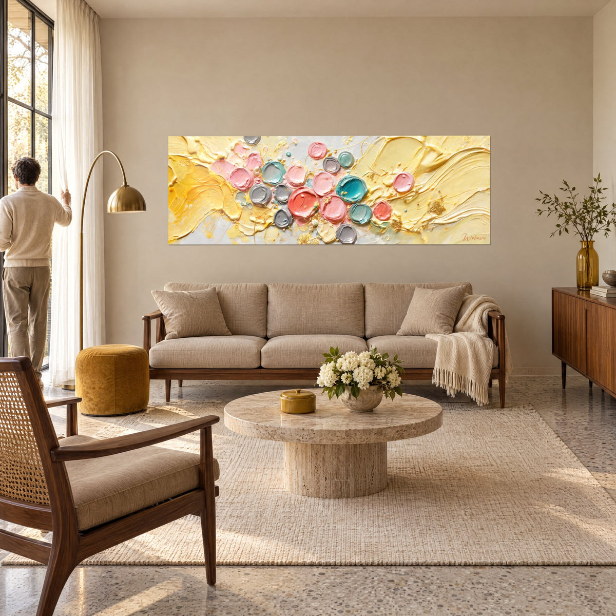Tableau pastilles de peinture épaisse rose et turquoise sur fond jaune beurre, au-dessus d'un canapé dans un salon lumineux