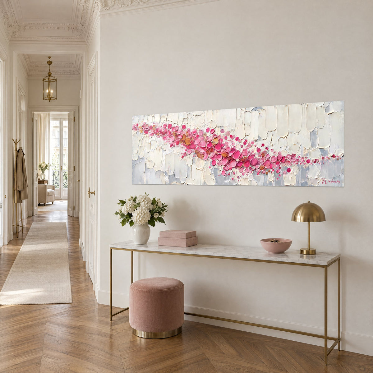 Tableau ruban diagonal de pastilles roses et dorées sur fond crème, au-dessus d'une console, couloir haussmannien