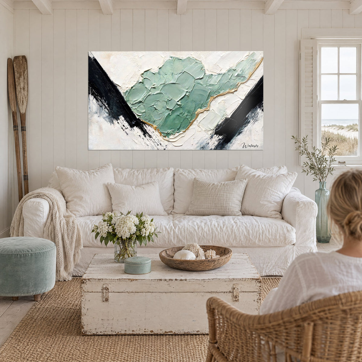 Tableau masse de peinture vert sauge en spatule, éclats noirs et filet doré sur fond crème, au-dessus d'un canapé dans un salon lumineux
