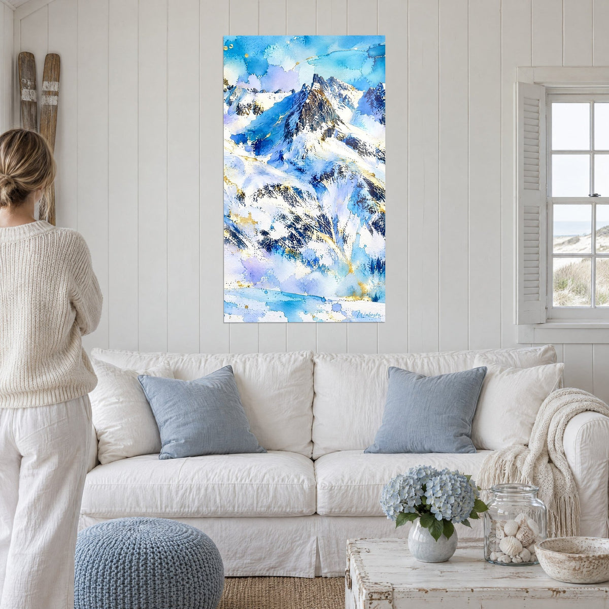 Tableau sommet rocheux en aquarelle bleu glacier et blanc neigeux, filets d'or, au-dessus d'un canapé dans un salon lumineux