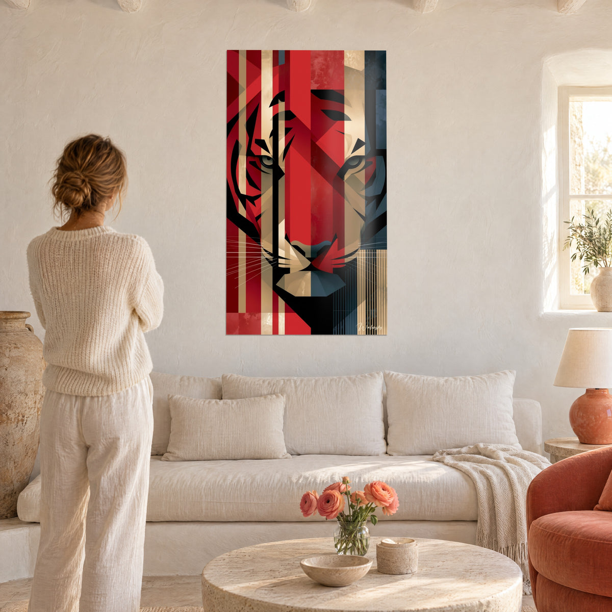 Schilderij geometrische vos met grijze ogen, rode en beige strepen, vrouw van achteren boven een bank in een lichte woonkamer