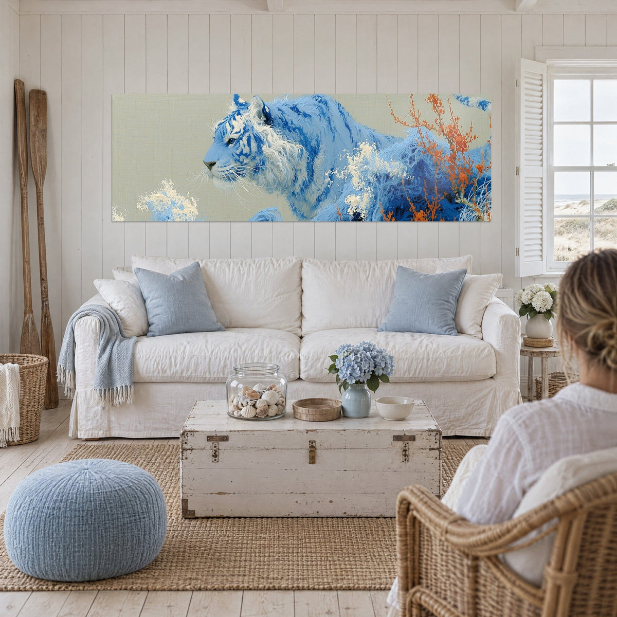 Cuadro felino azul cielo con melena marfil, ramas naranja intenso, encima de un sofá en un salón luminoso
