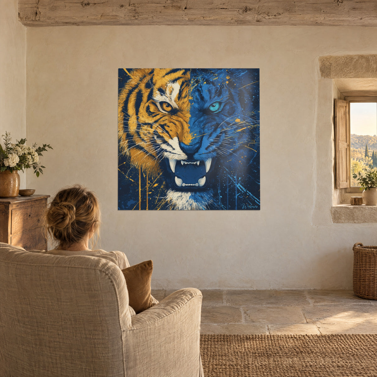 Cuadro gran felino salvaje, mitad amarillo ámbar, mitad azul profundo, colmillos brillantes, frente a una mujer de espaldas sentada en un sillón beige