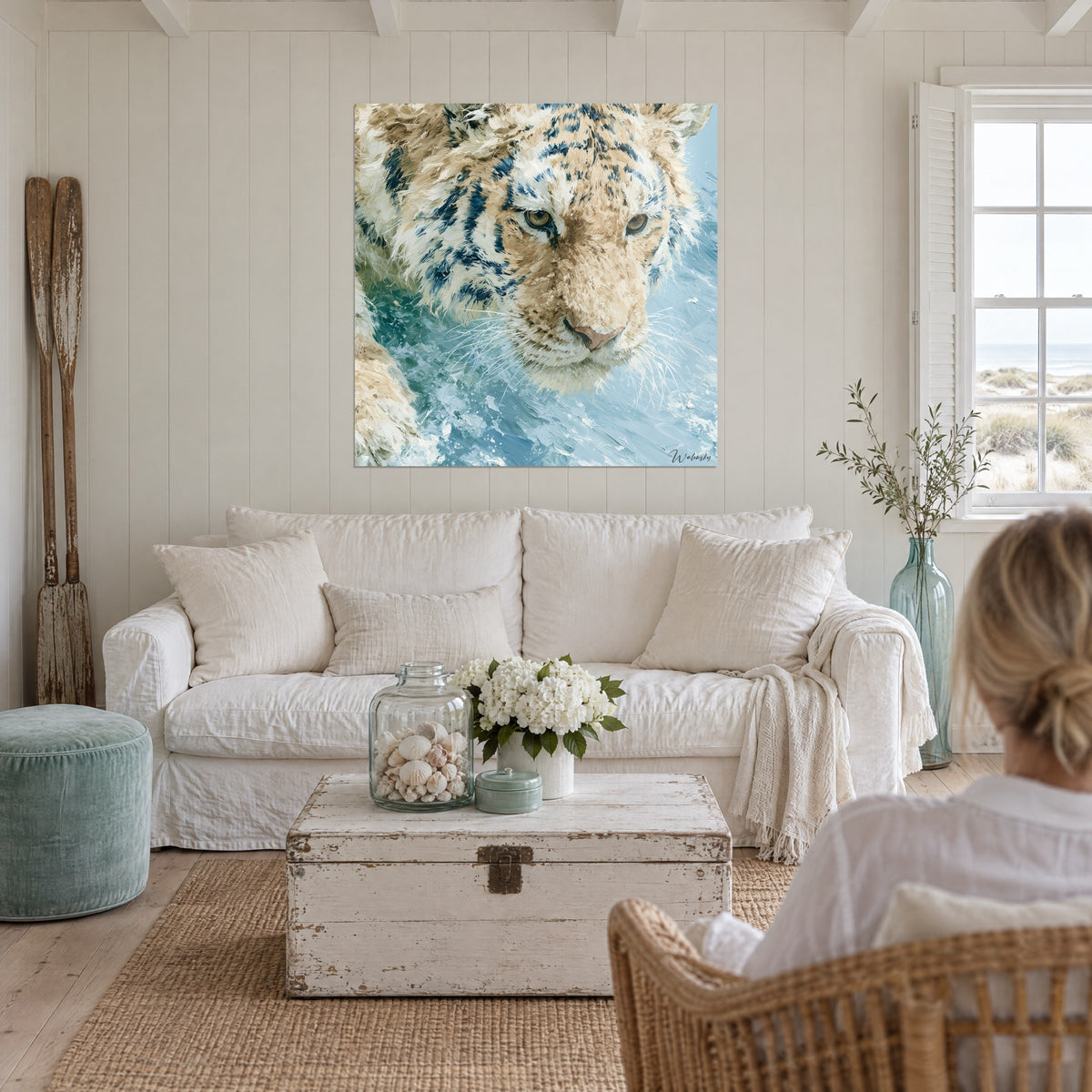 Tableau tigre blanc aux rayures bleu marine, regard ambre dans l'eau turquoise, au-dessus d'un canapé dans un salon lumineux
