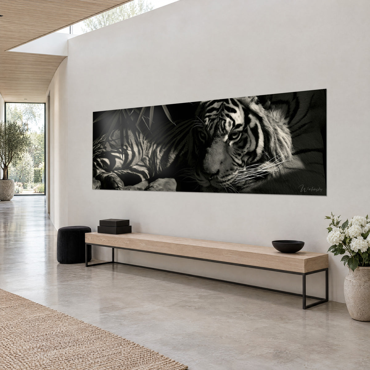 Tableau félin rayé couché, museau gris et moustaches blanches, fond noir de jais, vue de trois-quarts sur un mur crème