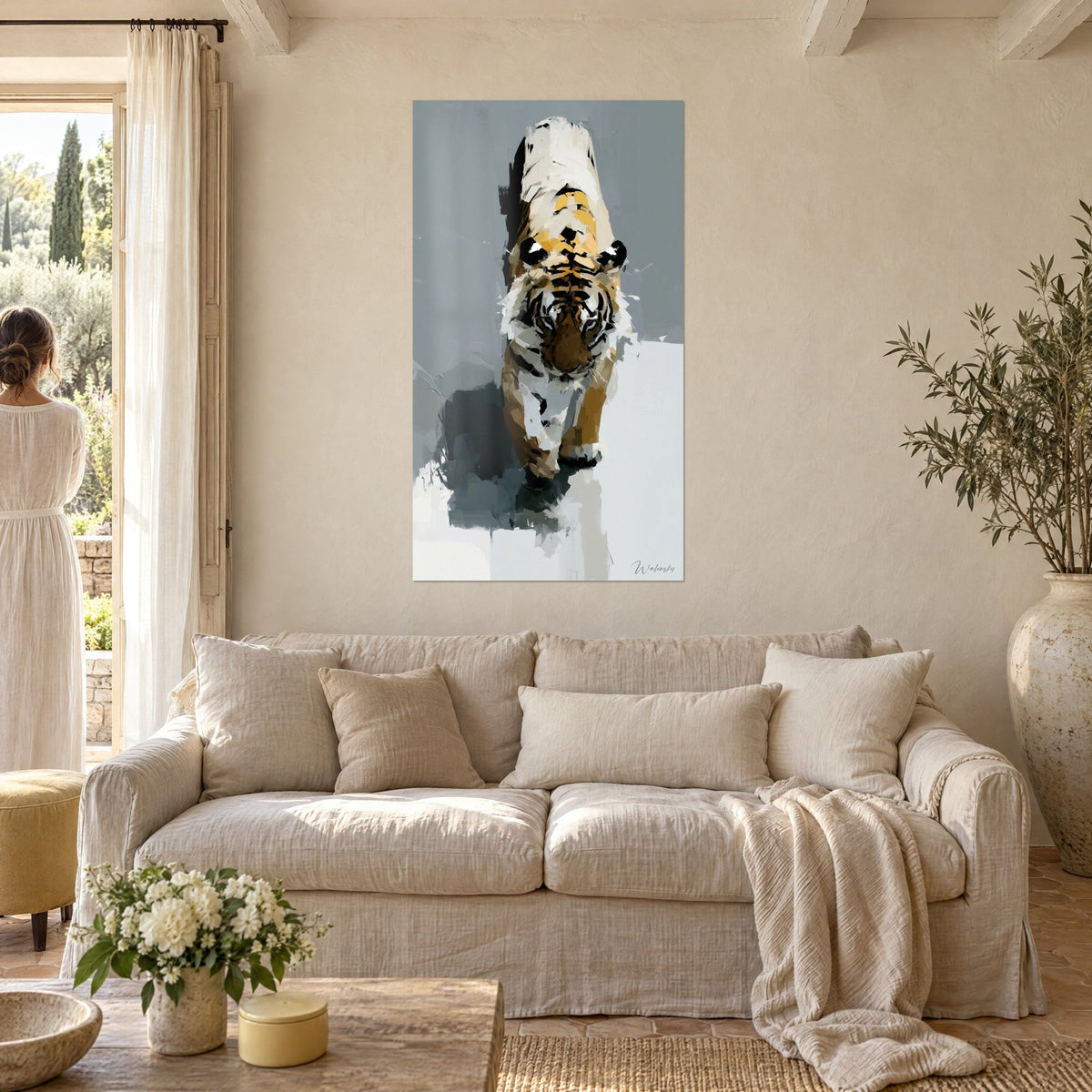 Wall art of a striped big cat advancing, ochre and cream fur in palette-knife strokes on a grey background, above a sofa in a bright living room