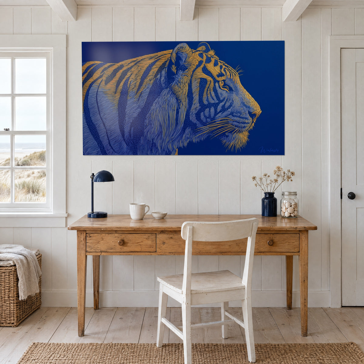 Quadro felino reale dai baffi bianchi e dal pelo dorato su sfondo blu marino, appeso dietro una scrivania in legno chiaro e alla sua lampada blu