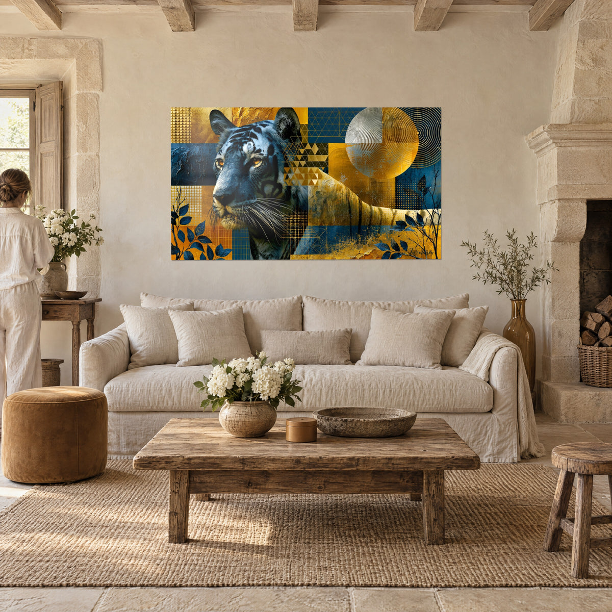 Wall art feline with amber eyes on gold and midnight blue mosaic, a person seen from behind, above a sofa in a bright living room