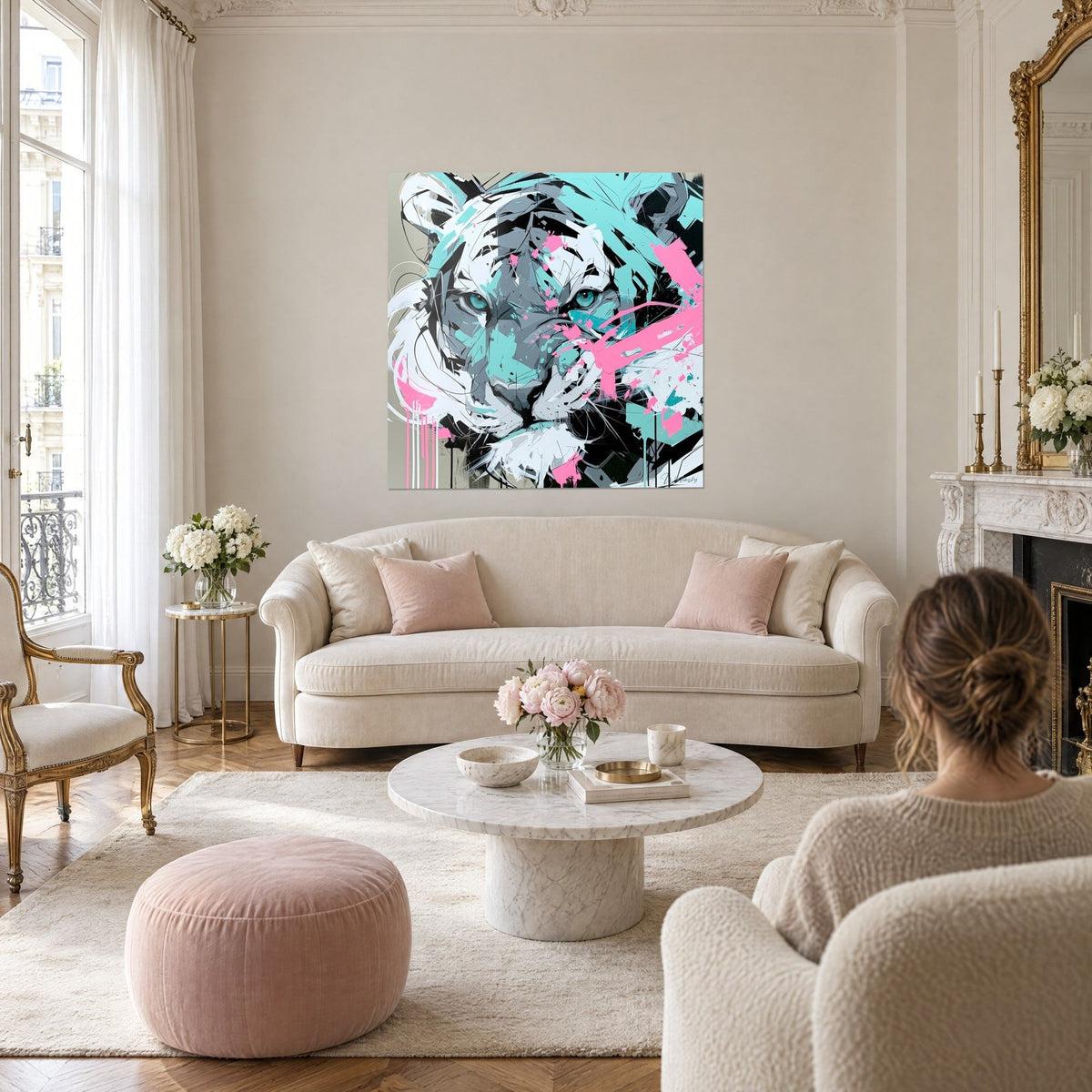 Wall art of a white feline with turquoise eyes, pink splashes, two people seen from behind, above a sofa in a bright living room