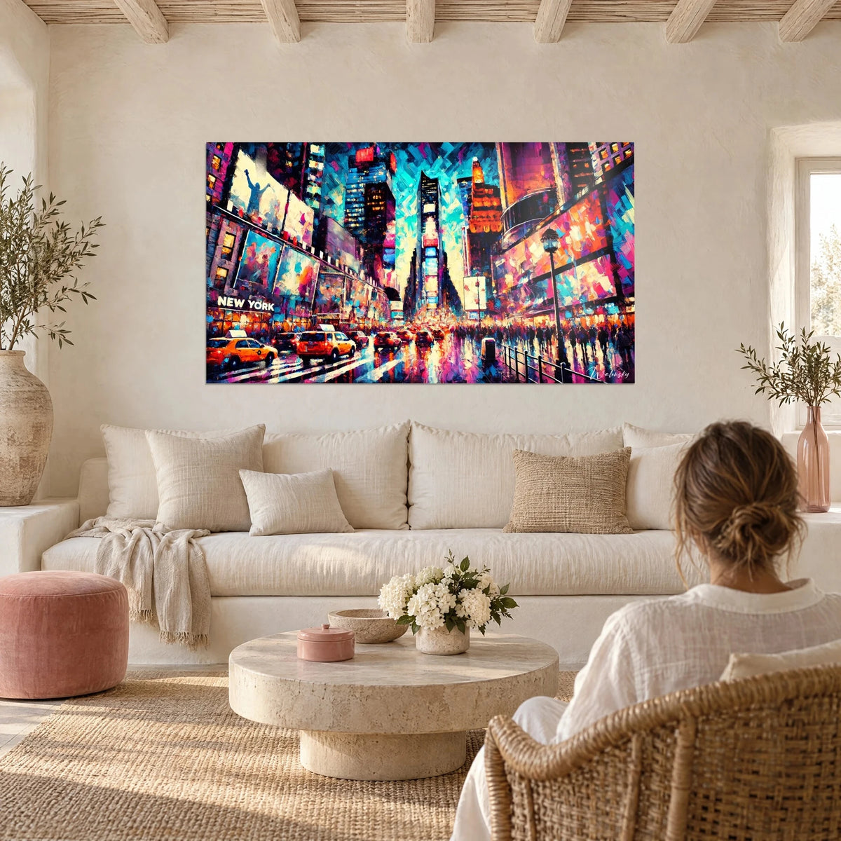 Quadro Times Square dipinto, taxi gialli e neon rosa e ciano, donna di spalle, sopra un divano in un soggiorno luminoso