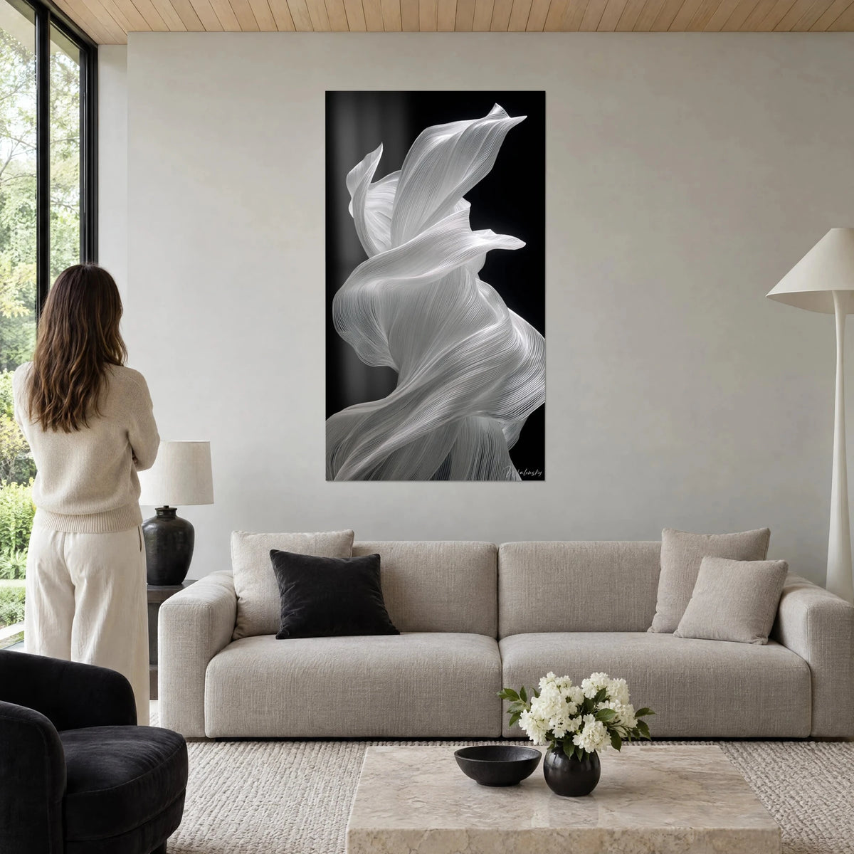 Tableau voile de soie blanche tourbillonnant sur fond noir, femme de dos, au-dessus d'un canapé dans un salon lumineux