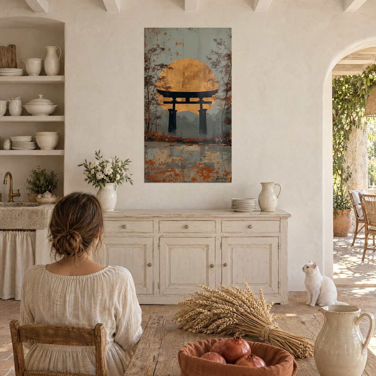 Schilderij met een donkere torii uitgesneden tegen een gouden hemellichaam, roestkleurige herfstbomen, een vrouw van achteren en een witte kat in de eetkamer