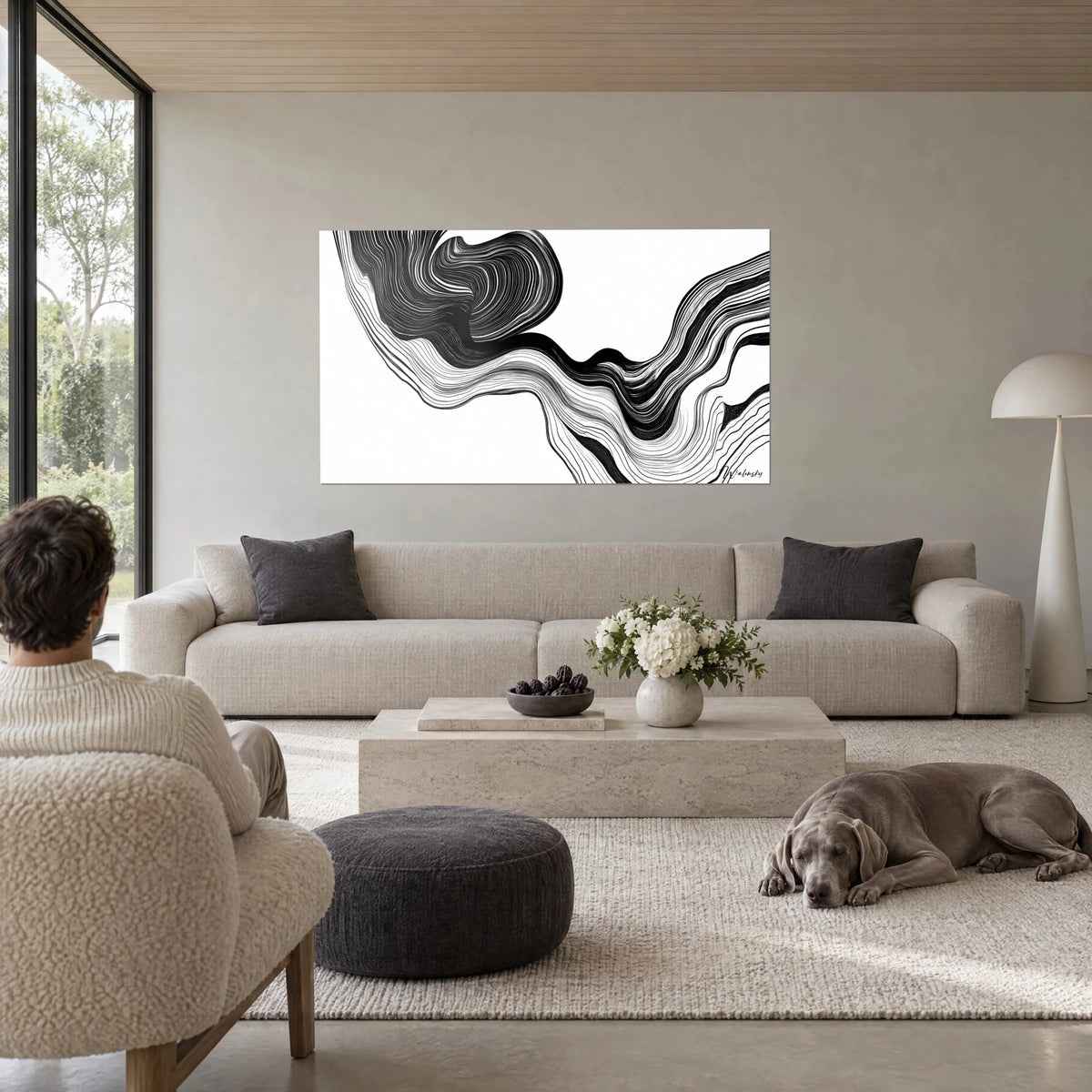 Wall art black ink ripples on a white background, a spiral of fine, tight lines, hung above a sofa in a bright living room