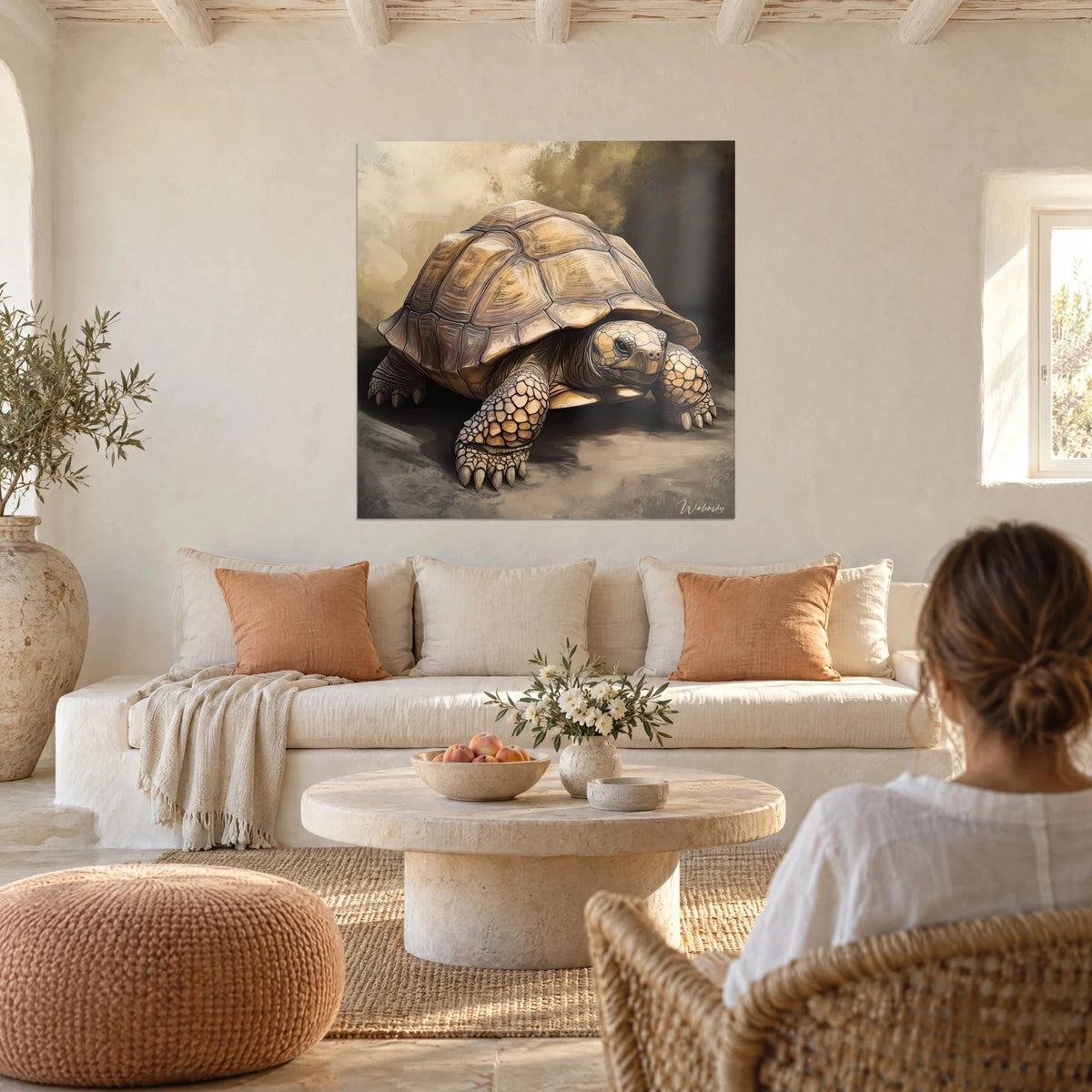 Tableau tortue terrestre à carapace ocre sur fond brun fumé, femme de dos, au-dessus d'un canapé dans un salon lumineux