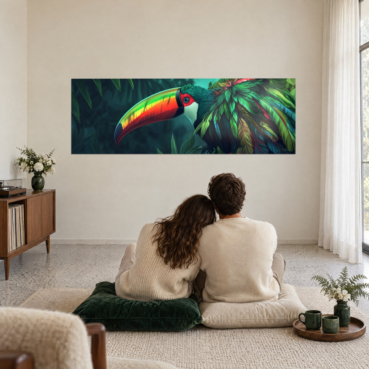 Cuadro gran pico luminoso amarillo y rojo, hojas verde oscuro de la selva amazónica, una pareja abrazada de espaldas sobre cojines