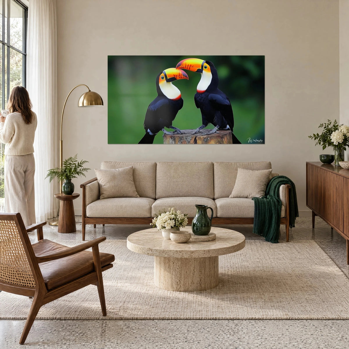 Schilderij toekanpaar met oranje en gele snavels, zwart verenkleed, witte borst op groene achtergrond, boven een bank in een lichte woonkamer