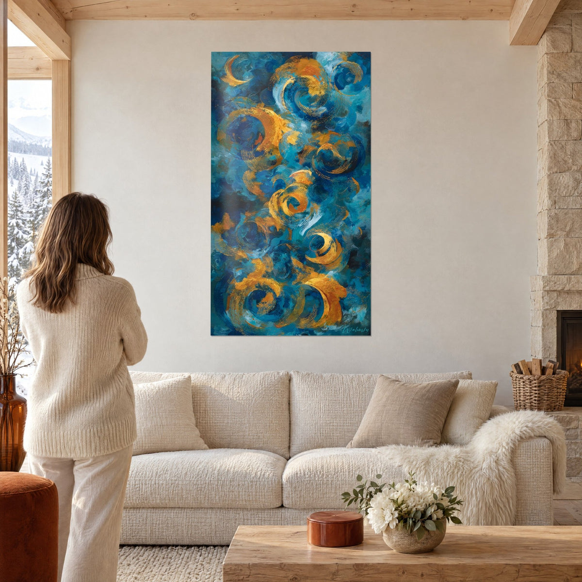 Tableau tourbillons dorés sur fond bleu nuit, spirales de pâte épaisse, femme de dos au-dessus d'un canapé dans un salon lumineux
