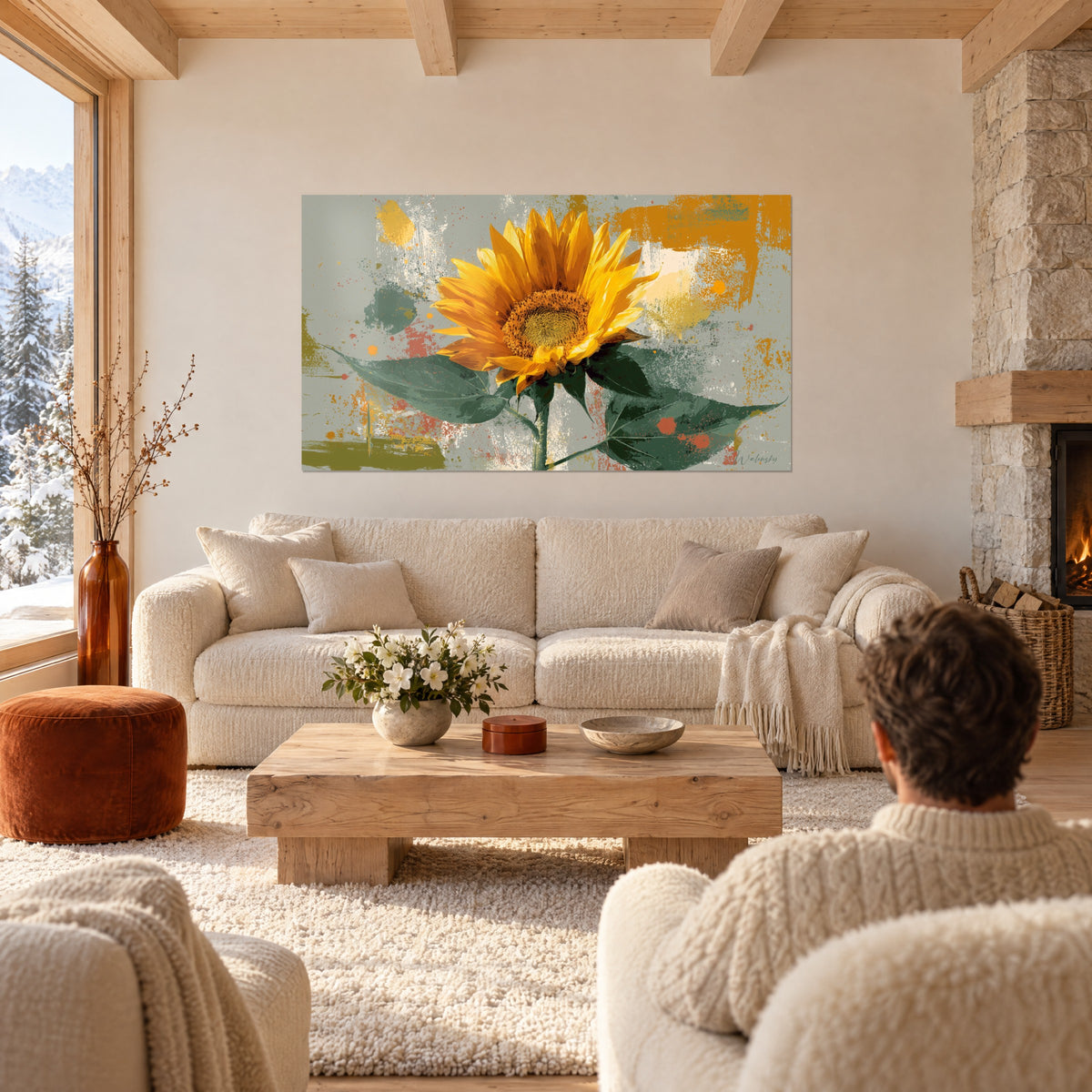 Wall art sunflower with golden petals and fir-green leaves, couple seen from behind, above a sofa in a bright living room