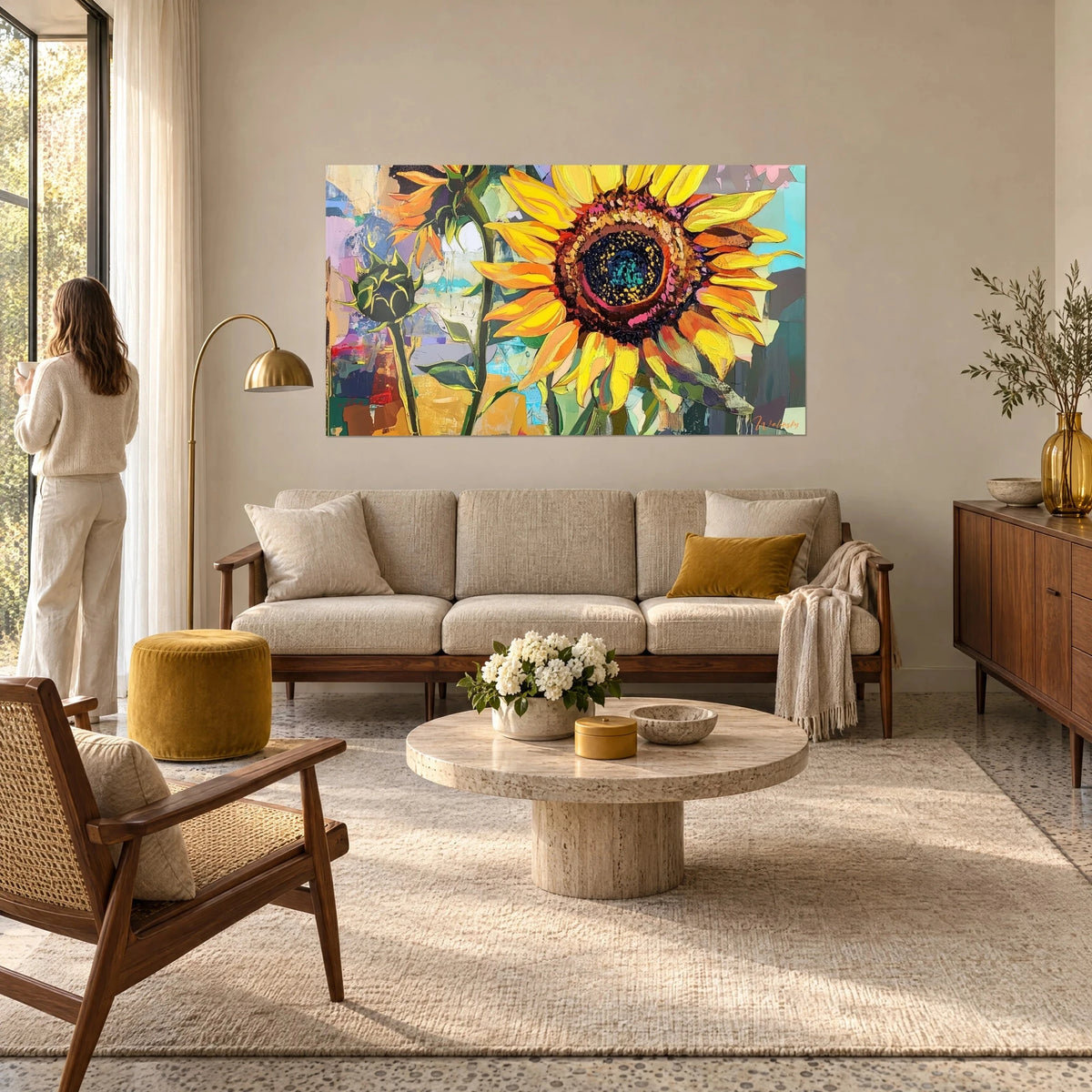 Cuadro gran girasol de pétalos amarillo vivo y anaranjados, centro marrón oscuro, fondo turquesa, sobre un sofá en un salón luminoso