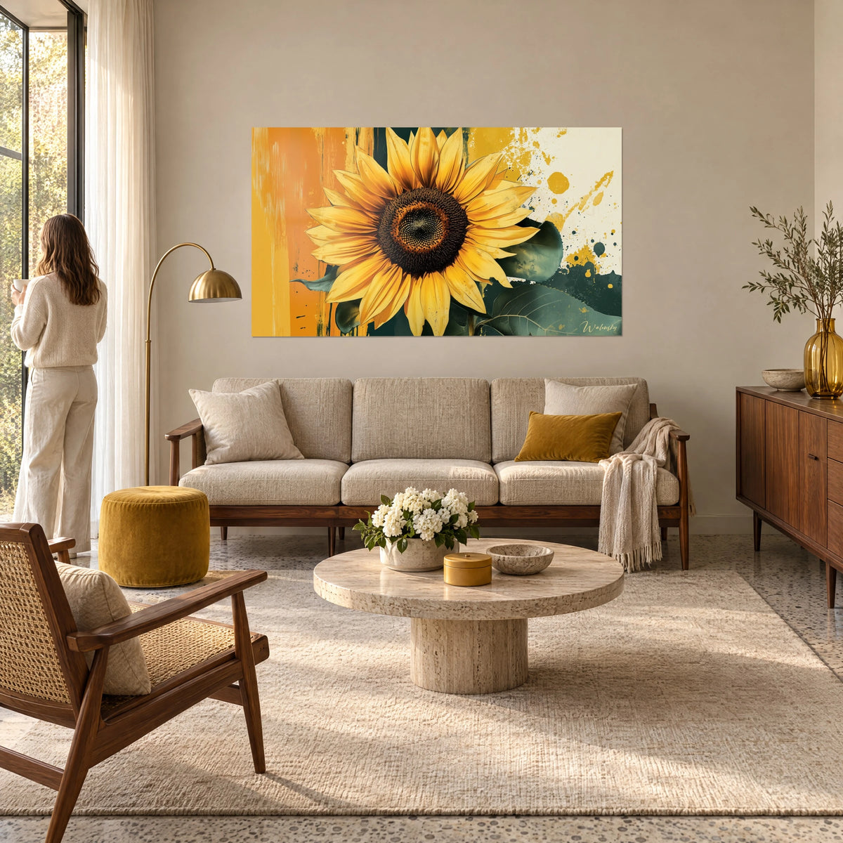 Cuadro girasol con pétalos amarillo azafrán y centro marrón, salpicaduras ocre, mujer de espaldas sobre un sofá en un salón luminoso
