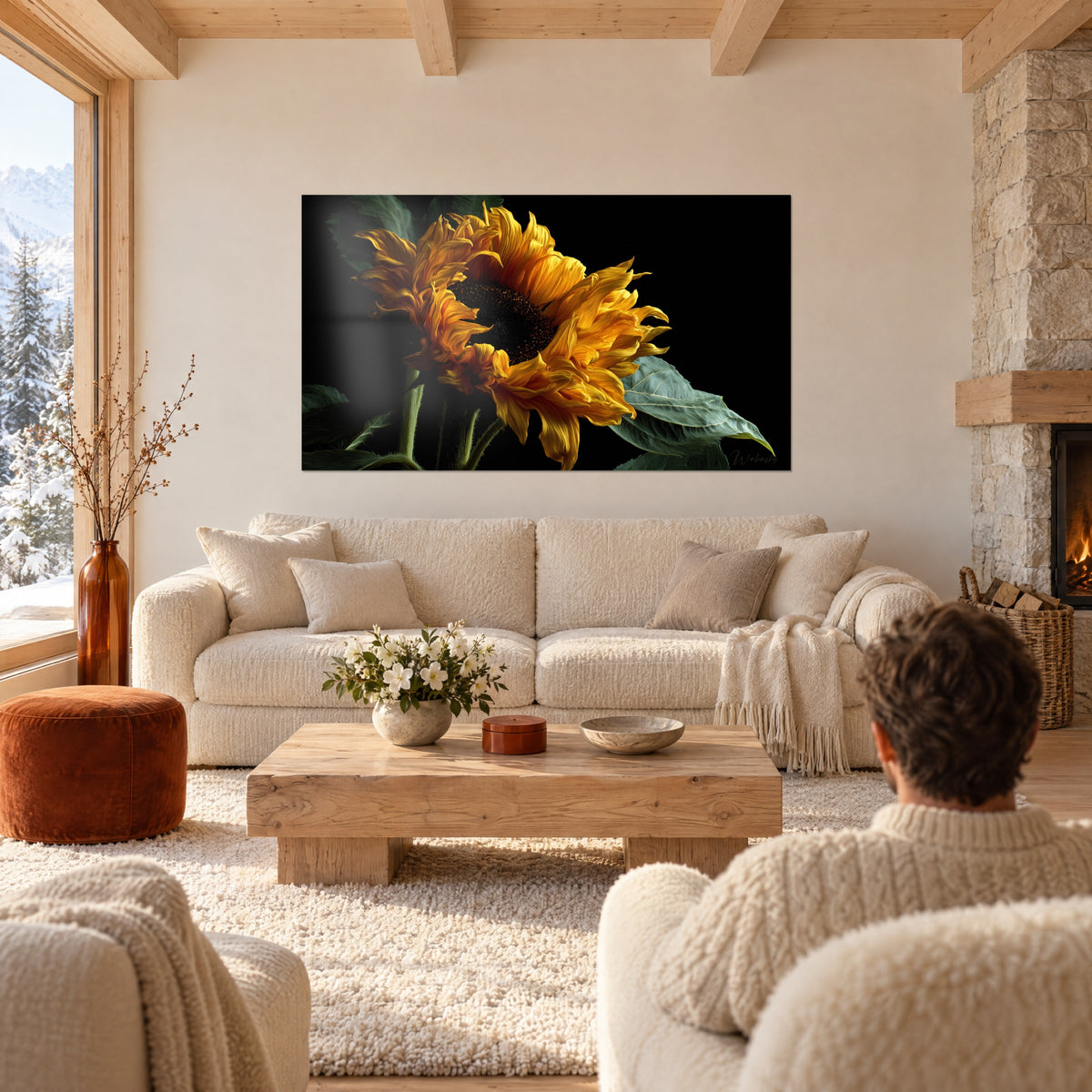 Schilderij zonnebloem met golvende oranje bladeren op een zwarte achtergrond, man van achteren, boven een bank in een lichte woonkamer
