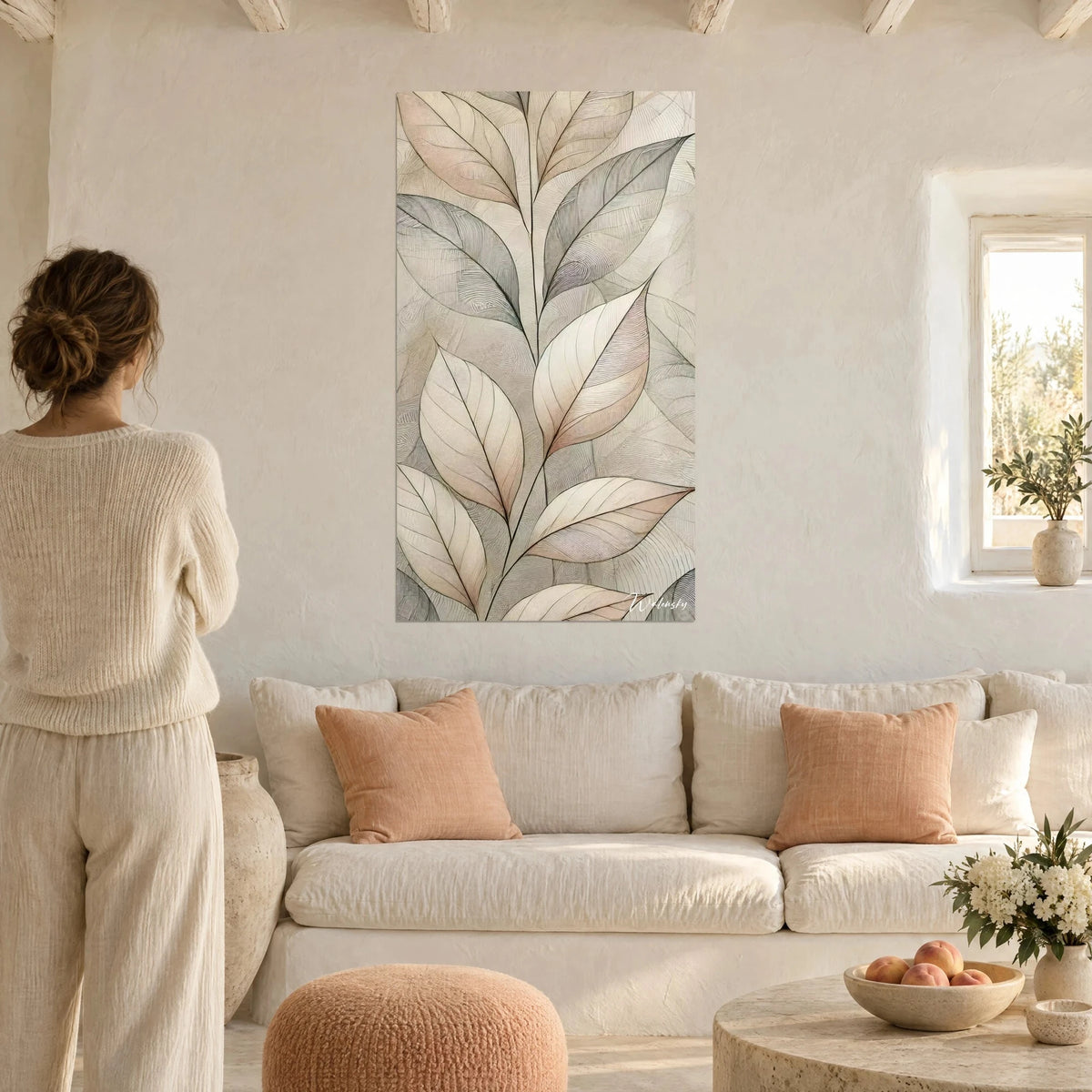 Tableau feuillage stylisé aux nervures noires, tons beige, rose poudré et gris, au-dessus d'un canapé dans un salon lumineux