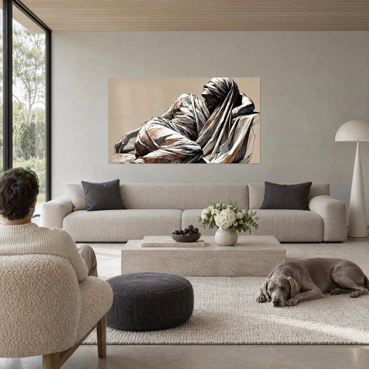 Tableau silhouette allongée sous un drap plissé, bruns cuivrés et blanc crème sur fond sable, au-dessus d'un canapé dans un salon lumineux