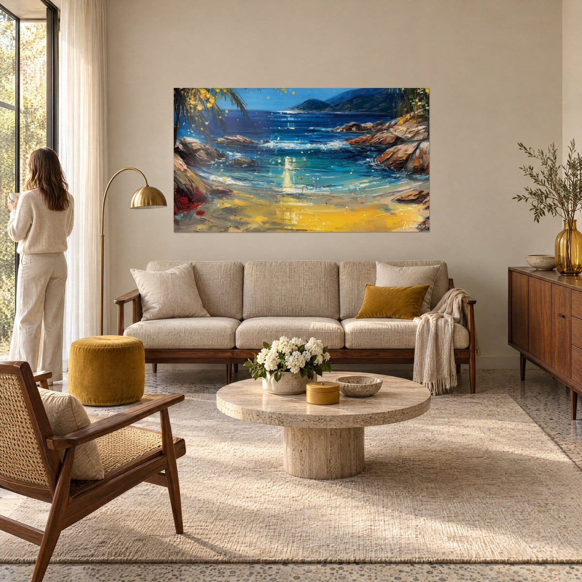 Tableau crique turquoise bordée de rochers ocre, sable doré et palmier en fleurs jaunes, au-dessus d'un canapé dans un salon lumineux