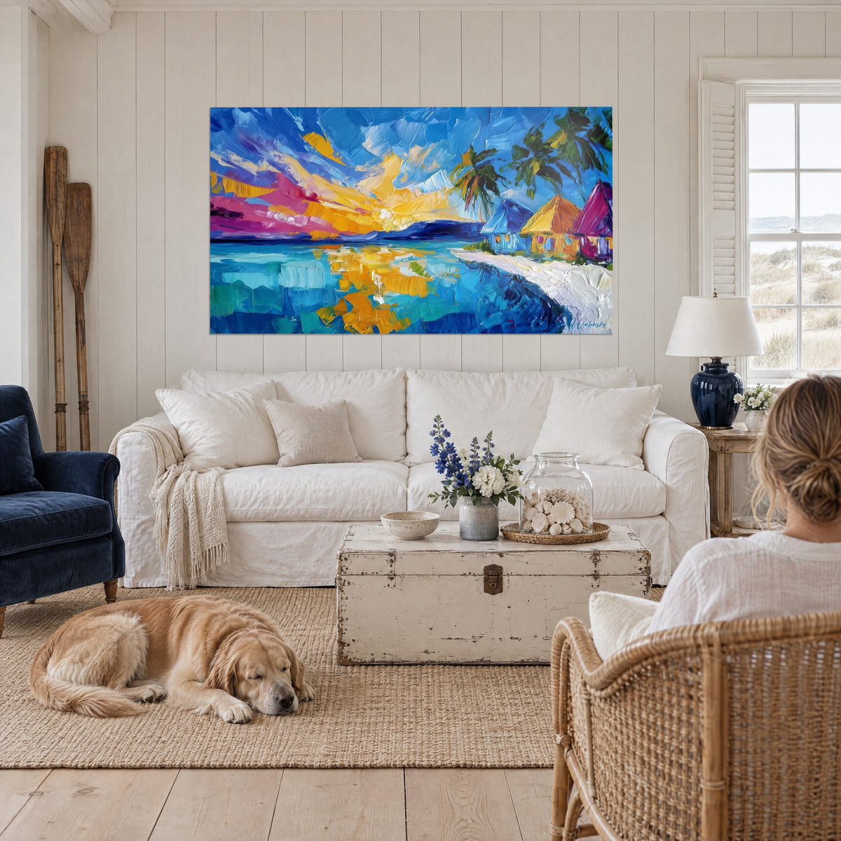 Tableau coucher de soleil tropical en pâte jaune et rose sur lagon turquoise, palmiers verts, au-dessus d'un canapé dans un salon lumineux