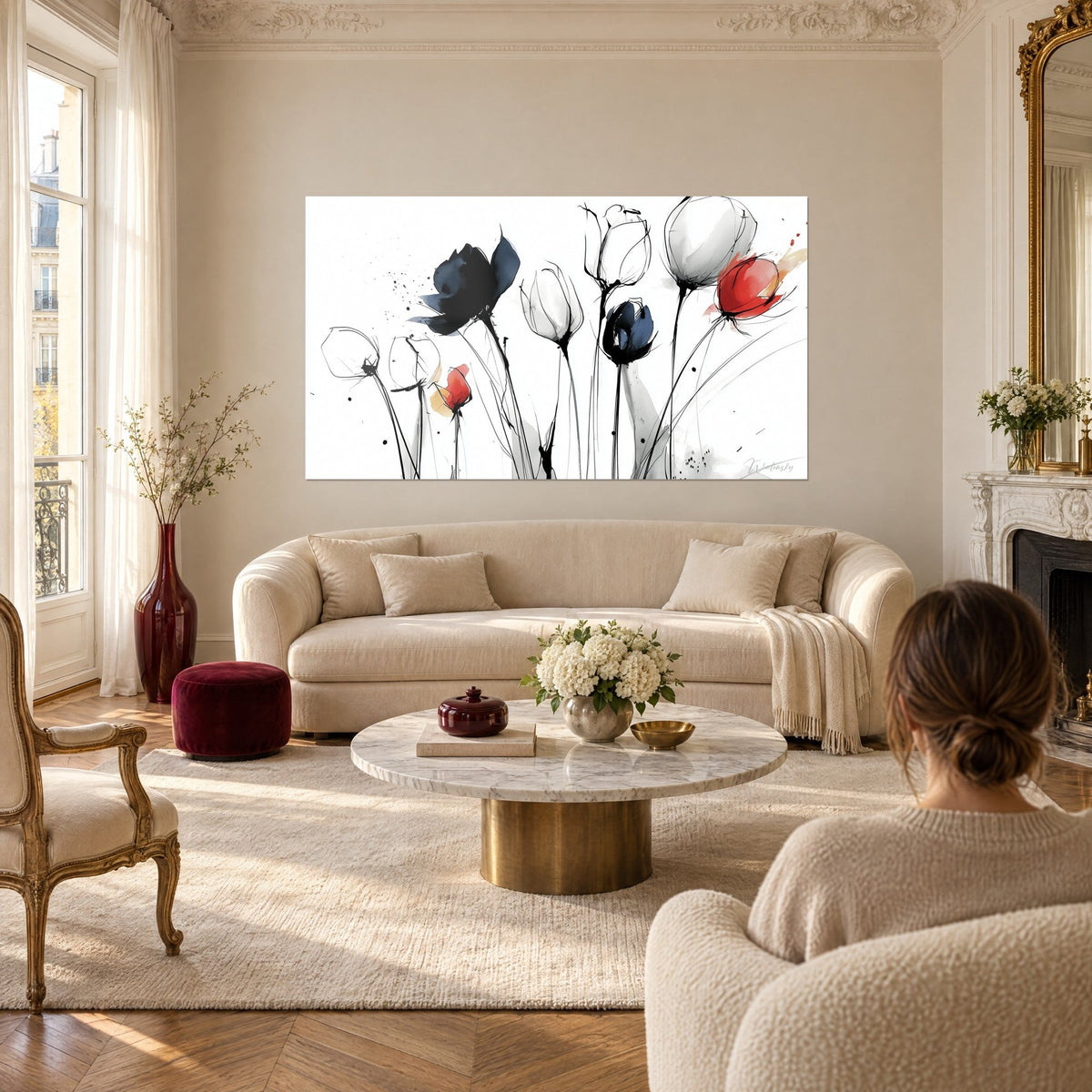 Wall art of tulips in black and bright red ink on a white background, thin stems, a woman seen from behind, above a sofa in a bright living room