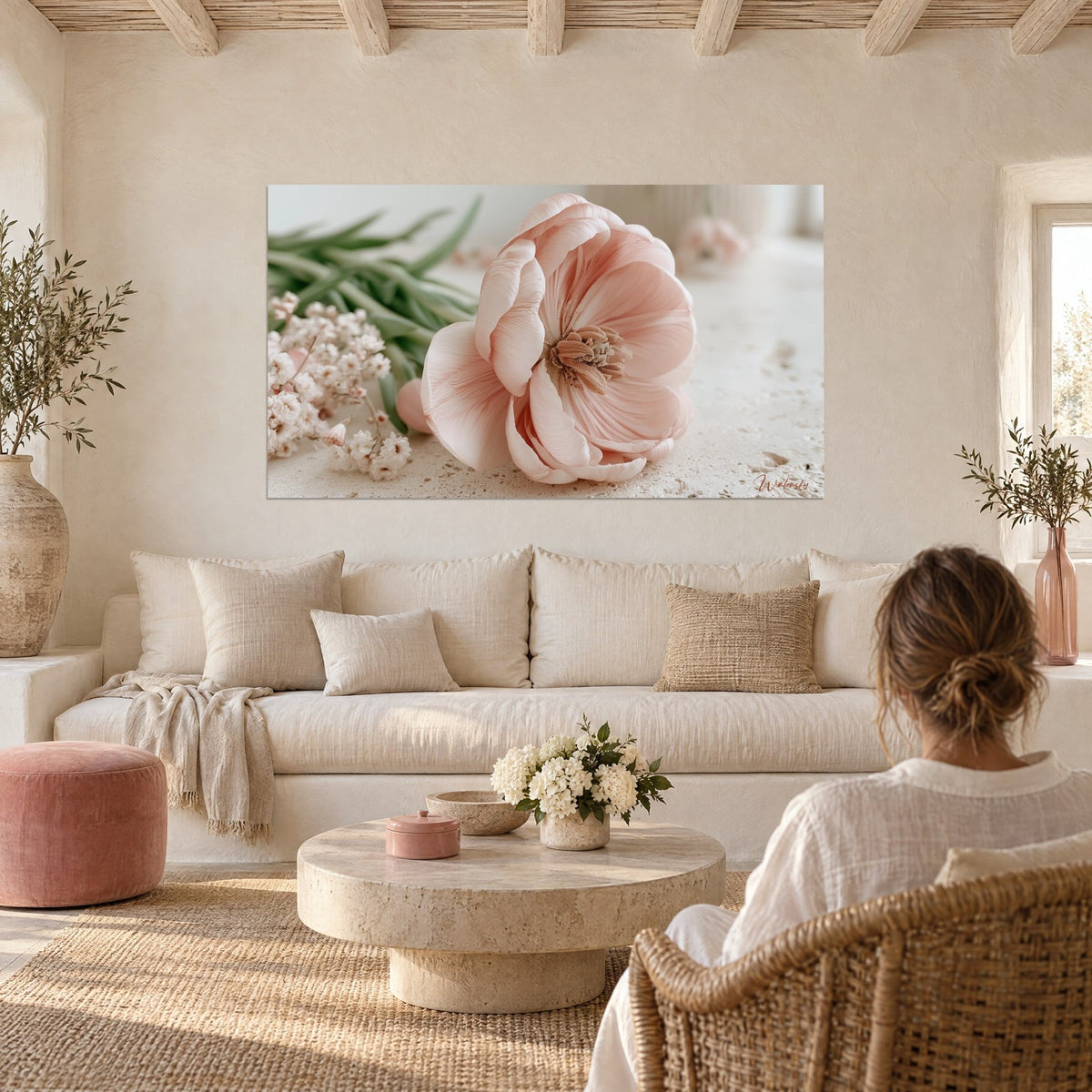 Tableau tulipe rose pâle aux pétales satinés, étamines brunes, fleurs blanches en fond, au-dessus d'un canapé dans un salon lumineux